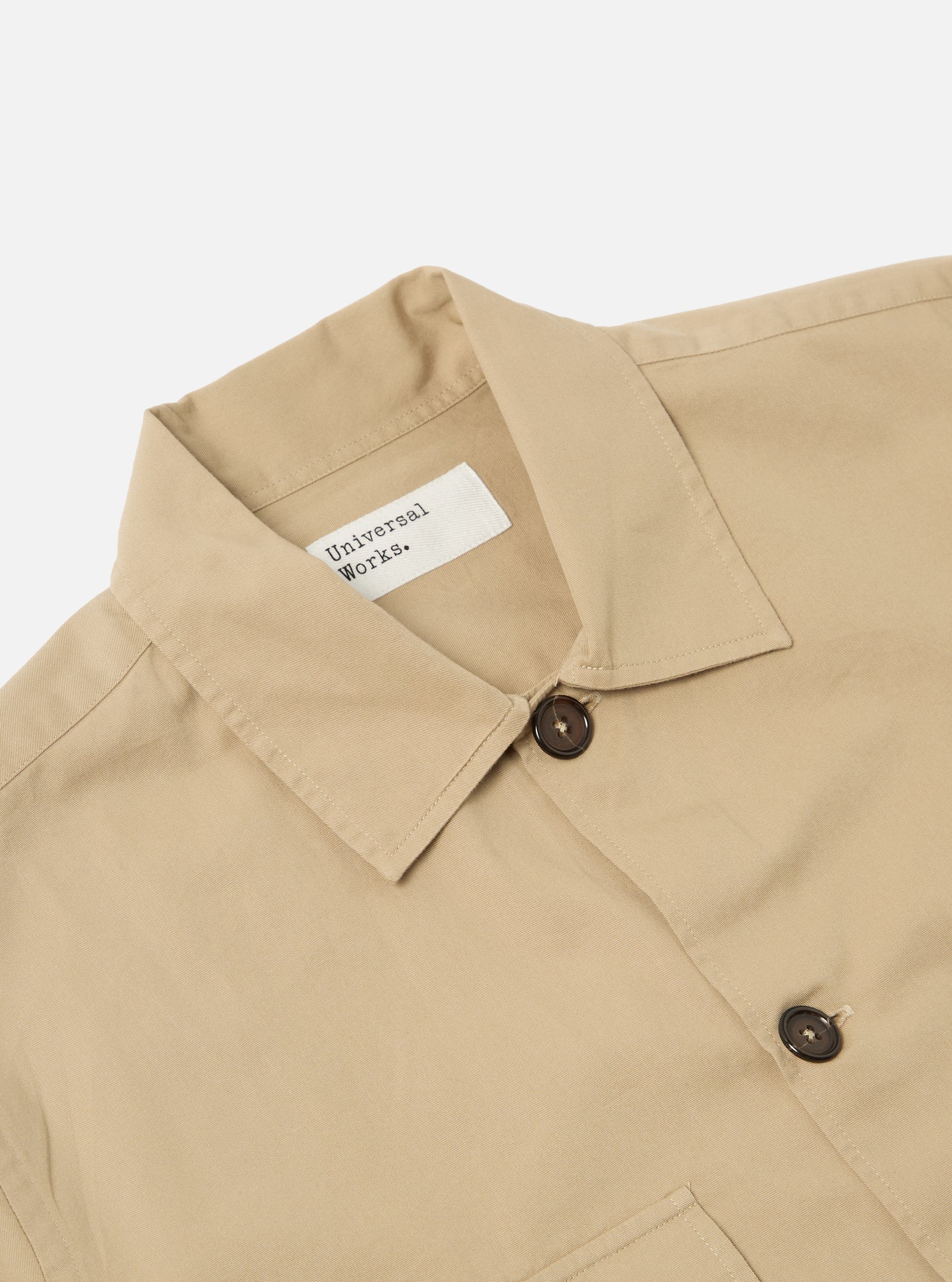 Close-up of the Sand Military Cotton Dockside Overshirt on a white background. The cotton overshirt has a classic collar and dark brown buttons.