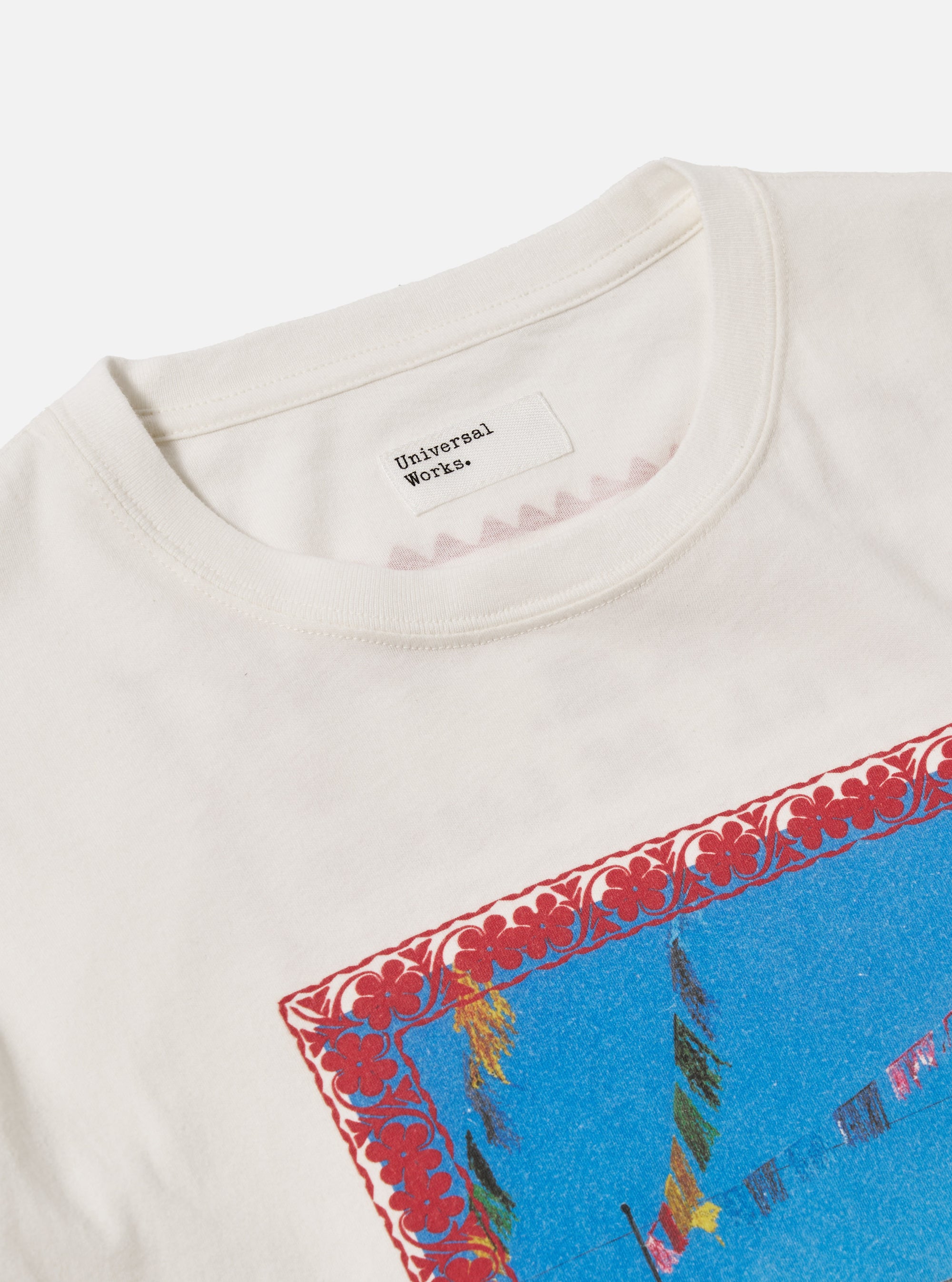 Close-up of the Ecru/Red Single Jersey Pickup Print Tee on a white background. The tee features a red print around the collar and a larger print on the front.