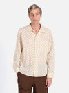 A man models the Camel Mitla Weave Work Shirt, cream with a brown woven pattern. He wears brown pants. Shot on a white background.