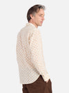 A man in profile on a white background wears the Camel Mitla Weave Work Shirt, a cream shirt with a brown woven pattern, paired with brown pants.