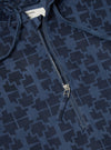 Close-up of the Navy Mitla Print Cord Liam Jacket. Features a blue corduroy material with a geometric print and a partial zipper. The background is a plain surface.