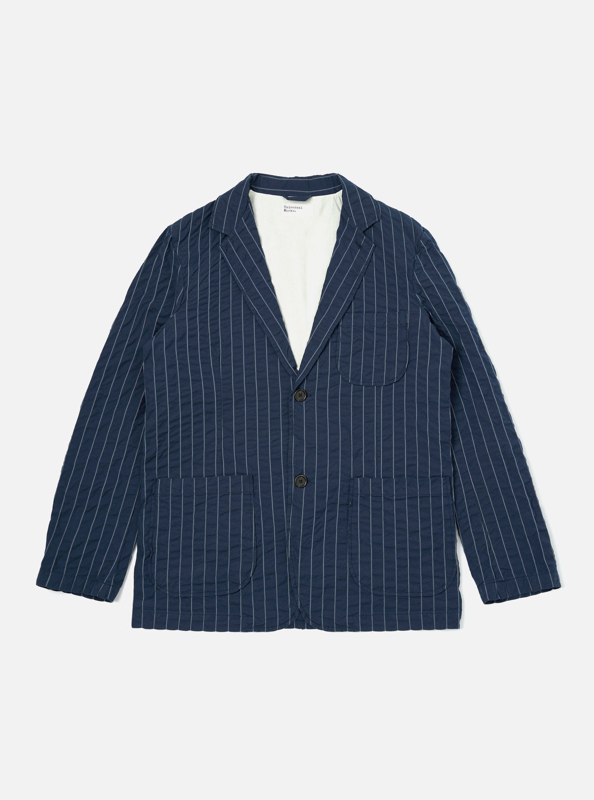 A Navy Chester Stripe Two Button Jacket is shown laid flat against a plain white background. The jacket features a thin vertical stripe pattern, two lower patch pockets, and one chest patch pocket. It has a classic notched lapel and a two-button front closure.