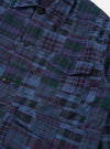 The Navy Madras Patchwork Duty Jacket is shown from the back, laid flat against a plain white background. The image highlights the patchwork construction of navy blue and multi-colored plaid cotton fabrics, featuring a straight hem and loose, darted sleeves.