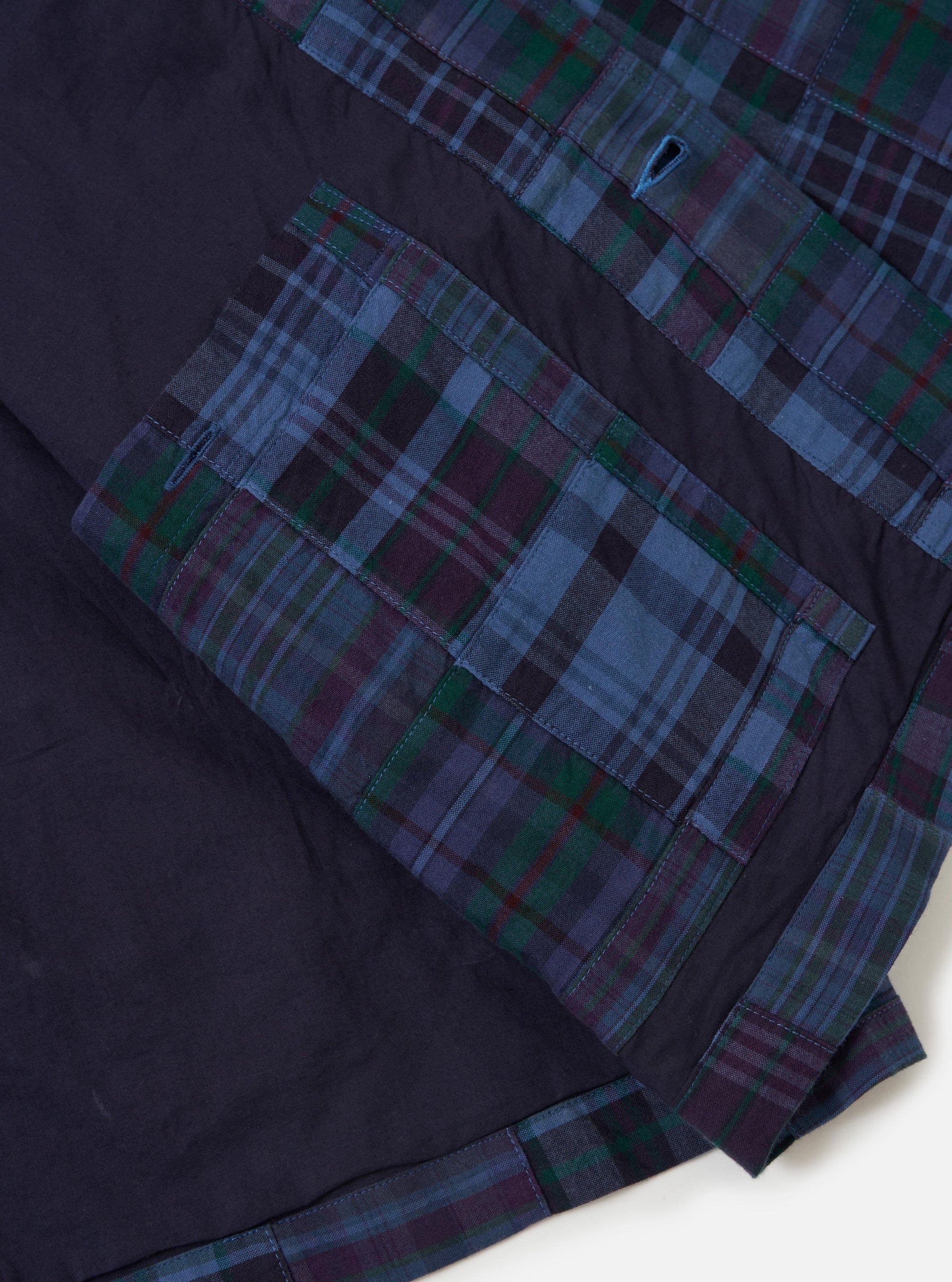 The Navy Madras Patchwork Duty Jacket is shown from the back, laid flat against a plain white background. The image highlights the jacket's straight hem, loose sleeves with darted details, and the intricate patchwork design featuring various navy and blue checkered patterns.
