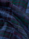 A close-up, square fabric swatch of the Navy Madras Patchwork Duty Jacket showcases an intricate patchwork design. The pattern consists of various intersecting navy, blue, and white plaid and checkered cotton fabrics, highlighting the textured weave of the material.