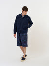 The Navy Linen Slub Weave E130 Jacket is displayed flat against a plain white background. The garment features a classic collar, a full-length button-down front, and two large patch pockets at the waist. The navy blue fabric has a visible slub texture.
