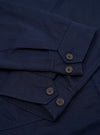 The Navy Linen Slub Weave E130 Jacket is shown from the back, laid flat against a solid white background. The image highlights the jacket's simple, clean construction, featuring a straight hem and a classic collar.