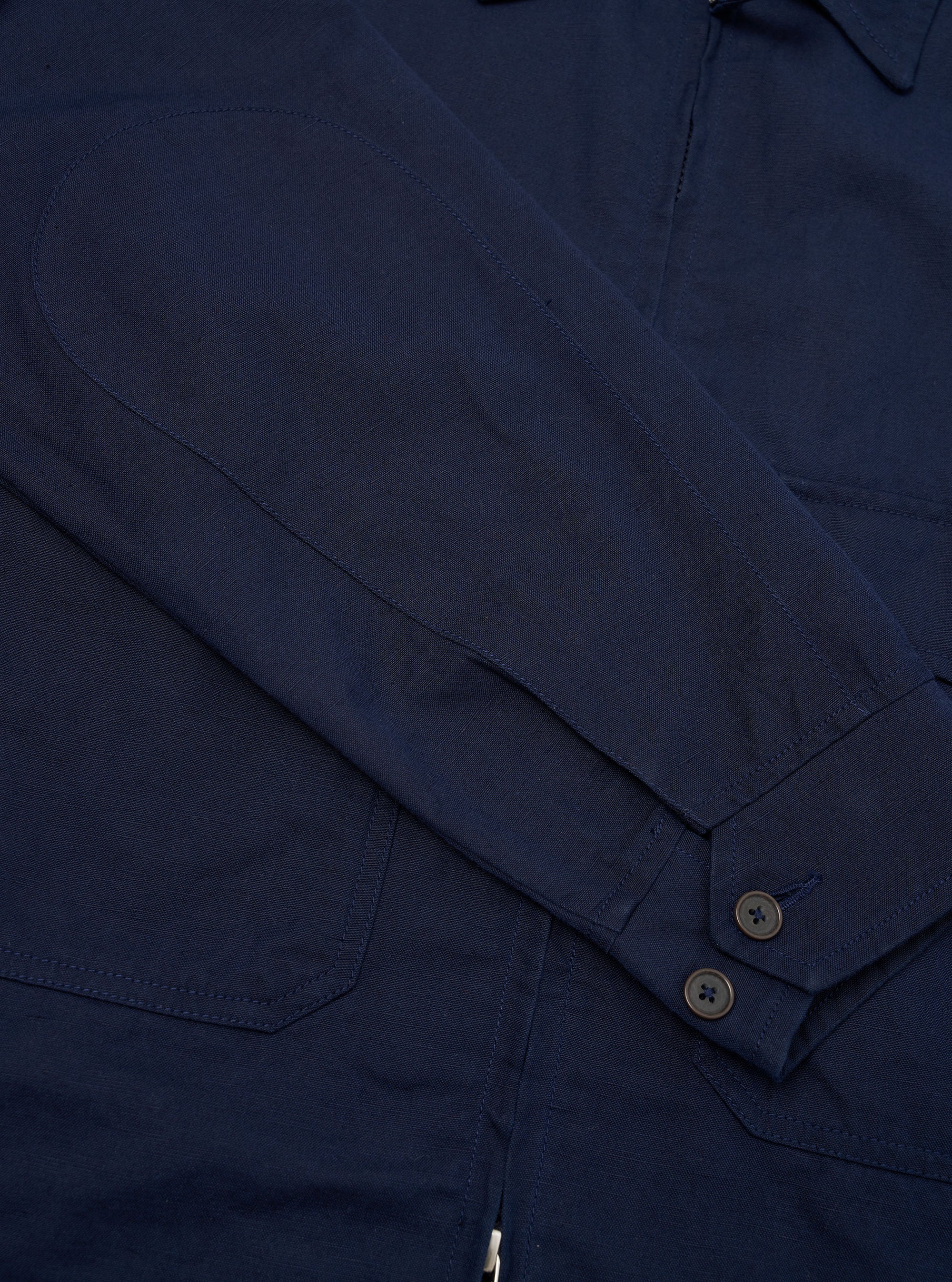 A rear view of the Navy Linen Slub Weave E130 Jacket is displayed flat against a plain white background. The image highlights the straight hem, the textured finish of the linen slub fabric, and the clean stitching across the shoulders and back panel.