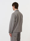 A model is seen from the back wearing the Mid Grey Linen Slub Weave Franck Jacket against a plain white background. The image highlights the jacket's regular fit, straight hem, and the textured appearance of the mid-grey linen-cotton blend fabric. No other models or mannequins are present.