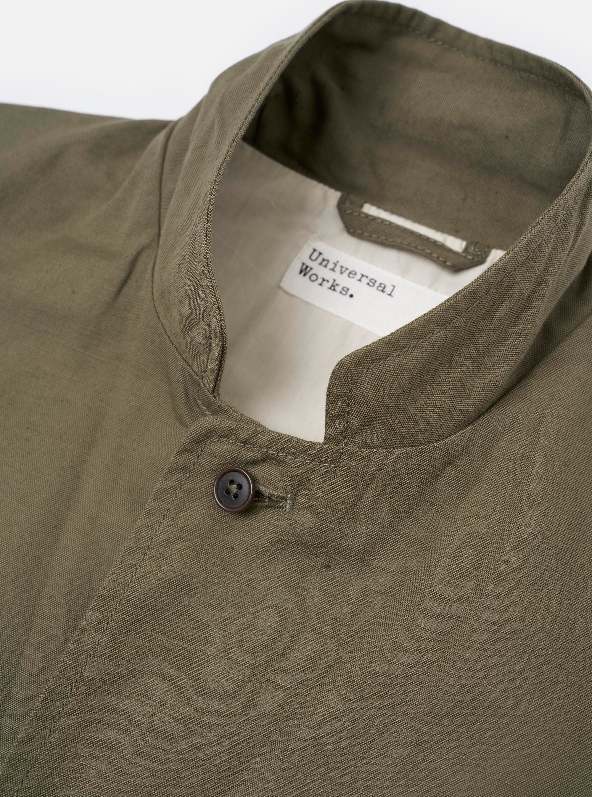 The Olive Linen Slub Weave Two Button Jacket is shown from a rear angle, laid flat against a plain white background. The image highlights the jacket's structured back, central rear vent, and the visible slub texture of the olive green fabric.
