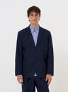 The Navy Linen Slub Weave Two Button Jacket is shown laid flat against a solid white background. The jacket features a relaxed fit with a two-button front, a notched lapel, two large lower patch pockets, and a single chest patch pocket. The fabric has a visible slub texture.