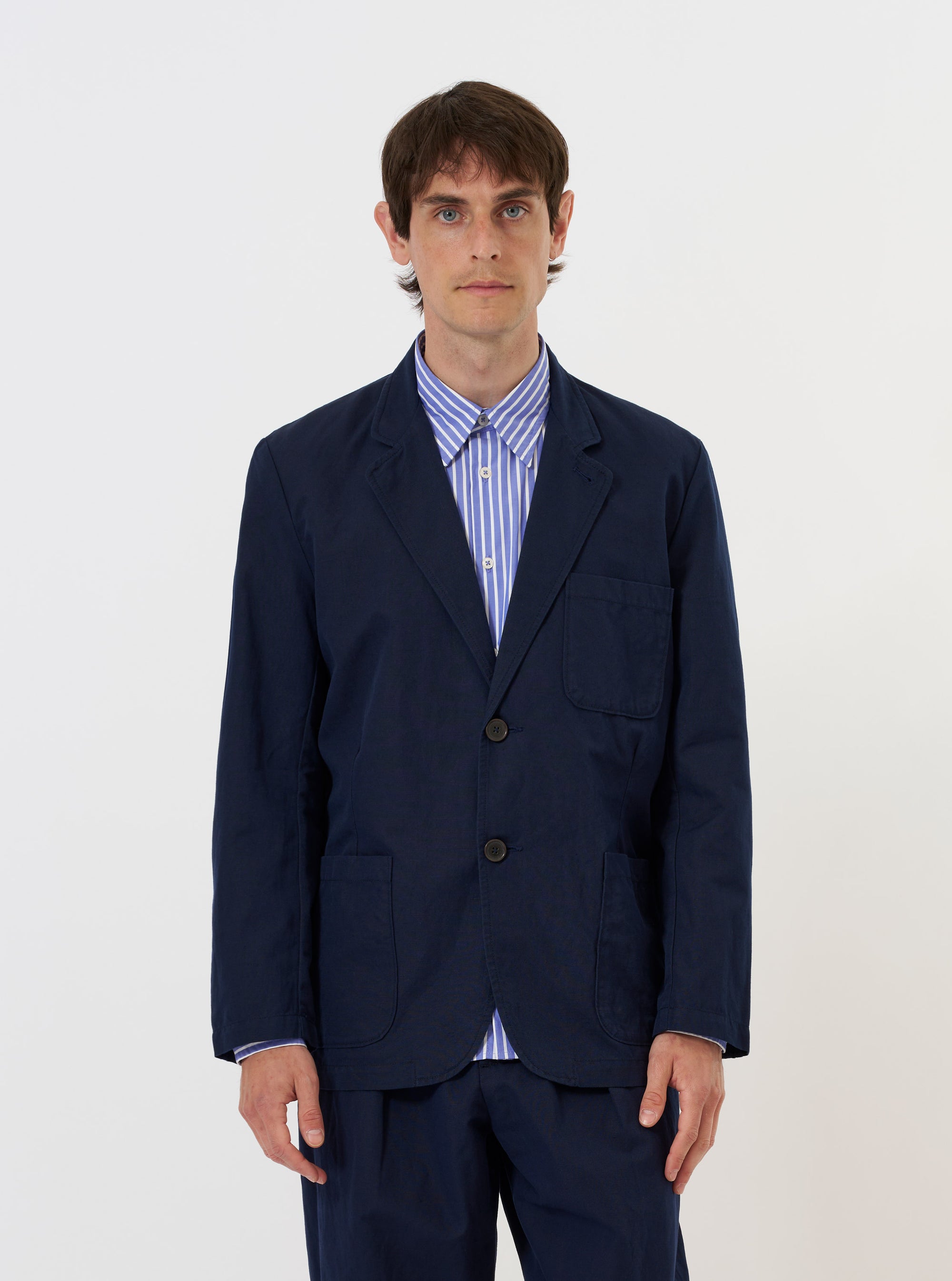 The Navy Linen Slub Weave Two Button Jacket is shown laid flat against a solid white background. The jacket features a relaxed fit with a two-button front, a notched lapel, two large lower patch pockets, and a single chest patch pocket. The fabric has a visible slub texture.
