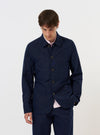 A navy blue linen slub weave Bakers Jacket is shown laid flat against a plain white background. The jacket features a five-button front, three front patch pockets, and a classic pointed collar. The textured slub weave of the fabric is visible.