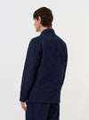 A Navy Linen Slub Weave Bakers Jacket is shown from a rear perspective, laid flat against a solid white background. The image highlights the jacket's structured back panels, straight hem, and the textured slub weave of the navy blue linen-cotton fabric.