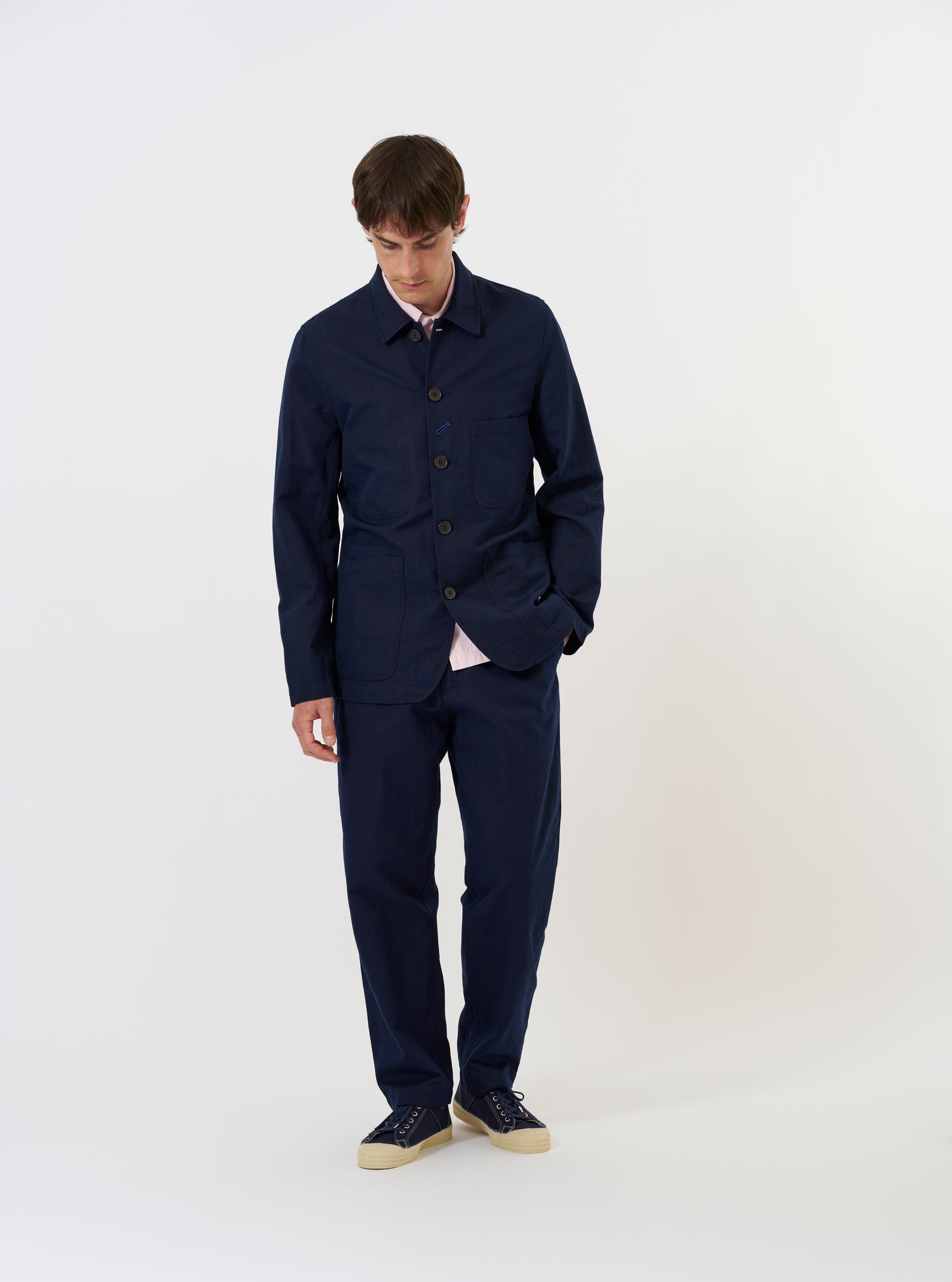 The Navy Linen Slub Weave Bakers Jacket is shown laid flat against a solid white background. The garment features a classic pointed collar, a five-button front, and three prominent patch pockets on the front, including one on the chest. The navy blue fabric has a visible slub weave texture.