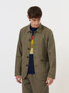 The Olive Linen Slub Weave Bakers Jacket is shown laid flat against a solid white background. The jacket features a classic chore coat silhouette with a five-button front, a pointed collar, and three prominent patch pockets on the front. The olive green fabric has a visible slub texture, and the garment is finished with a straight hem.