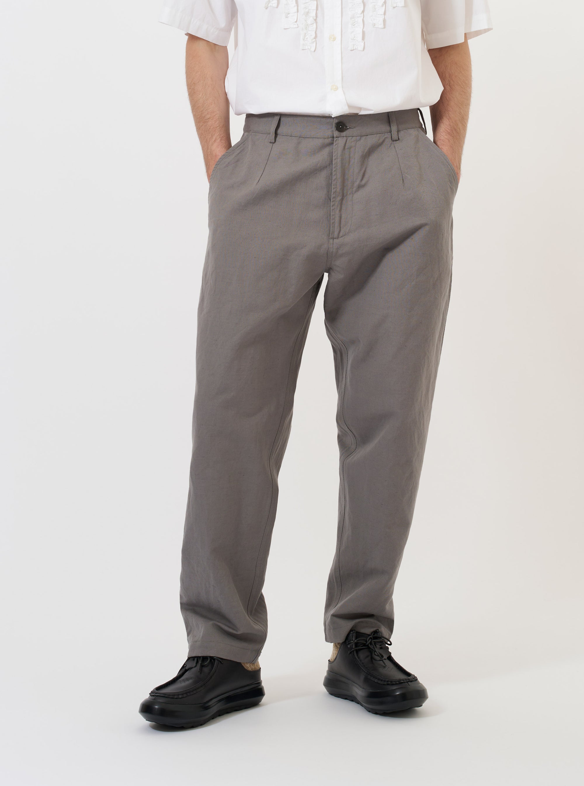 A pair of mid grey linen slub weave Dizzy trousers is displayed flat against a plain white background. The trousers feature a loose, wide leg with a slight taper, a fixed waistband, and two front angled pockets.