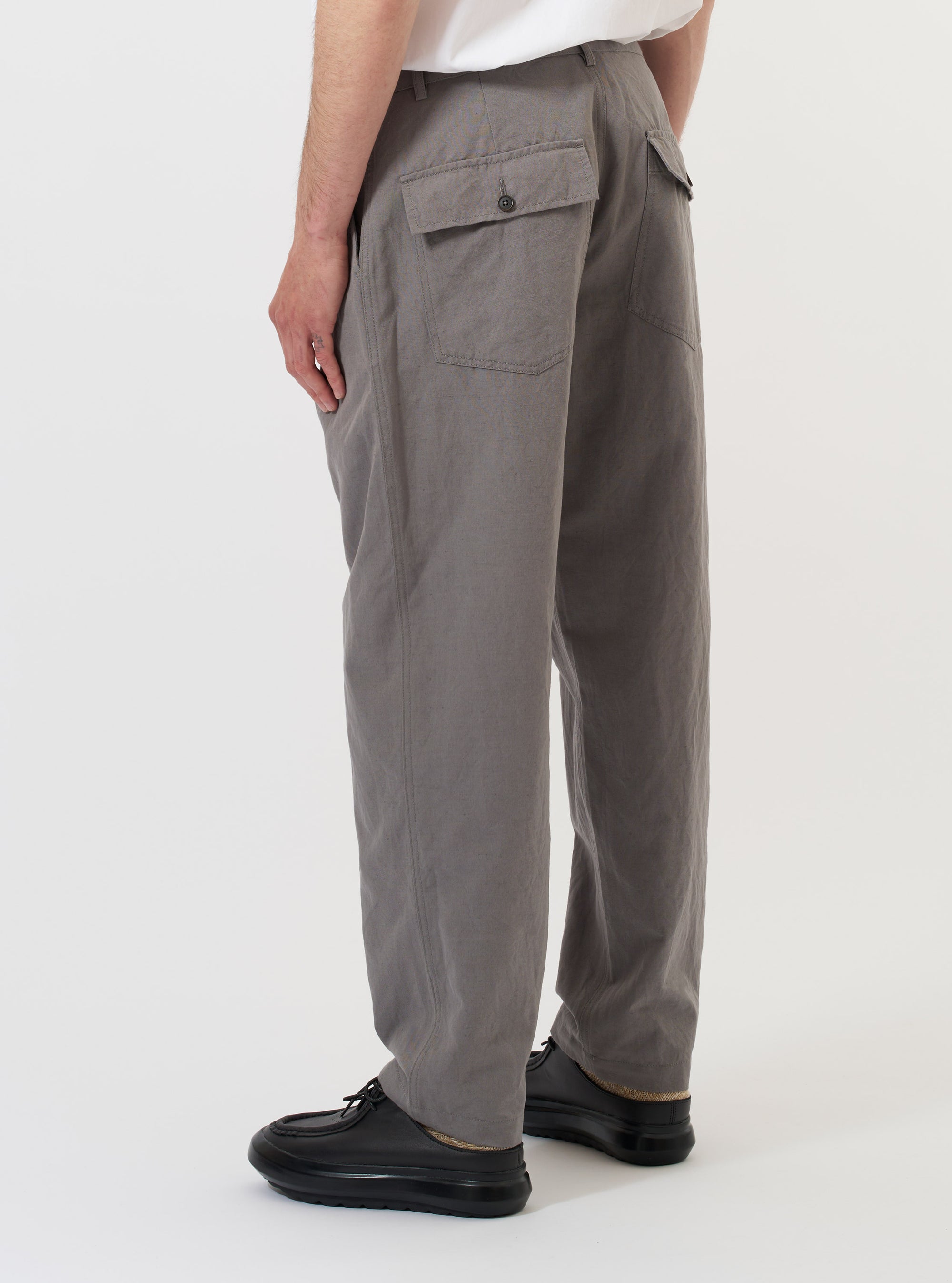 The back of the mid grey linen slub weave dizzy trousers is displayed flat against a plain white background. The garment features a wide-leg, loose fit and highlights the textured surface of the linen slub fabric.