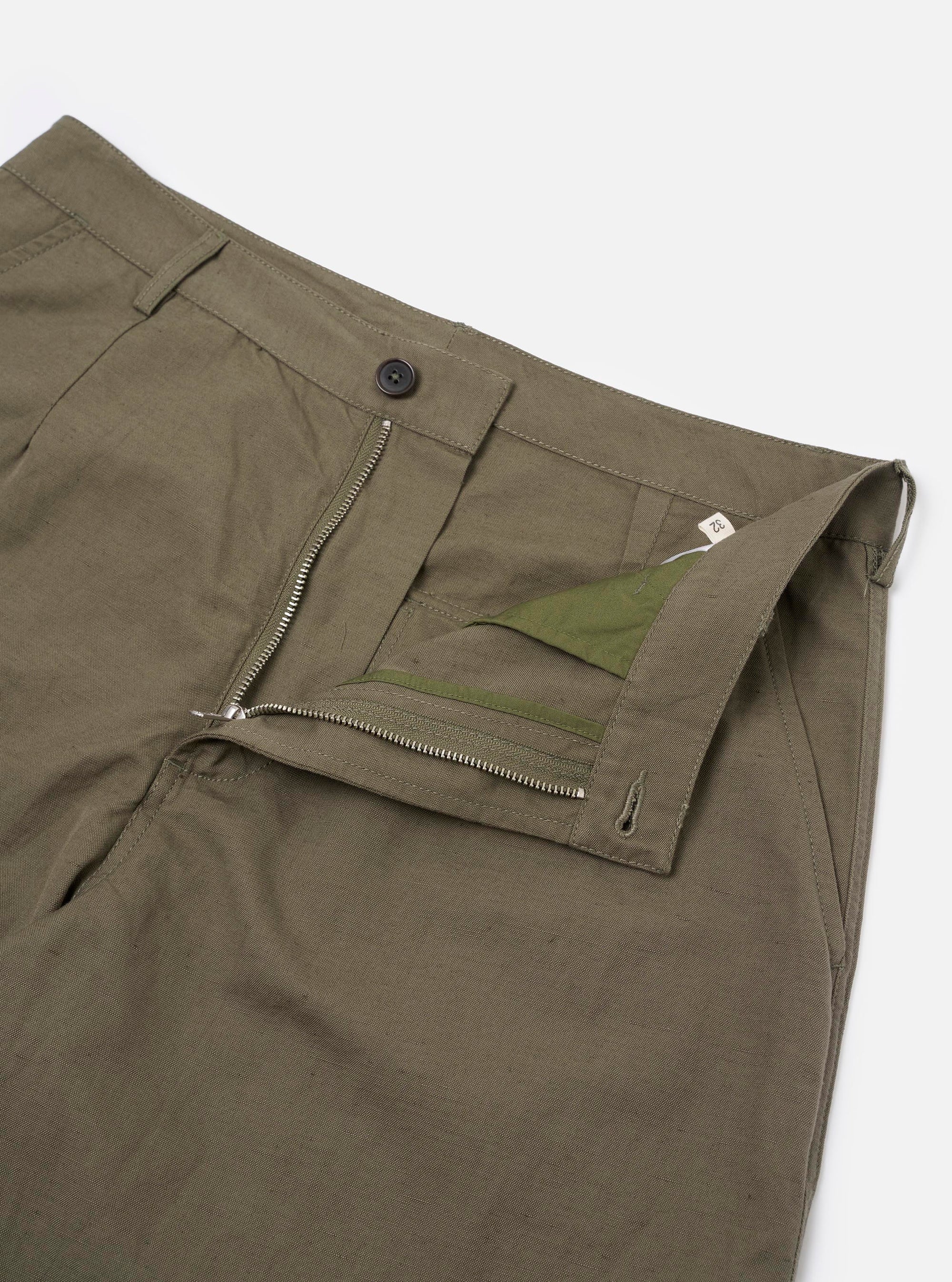 The Olive Linen Slub Weave Dizzy Trouser is shown from a rear angle, laid flat against a plain white background. The image highlights the two rear button-flap patch pockets, the fixed waistband with belt loops, and the wide, slightly tapered cut of the legs. The olive green fabric features a visible slub weave texture.