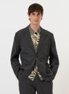 A model is wearing the Charcoal Seattle Cotton Two Button Jacket against a plain white background. The charcoal grey jacket features a classic two-button front closure, notched lapels, and a structured fit.