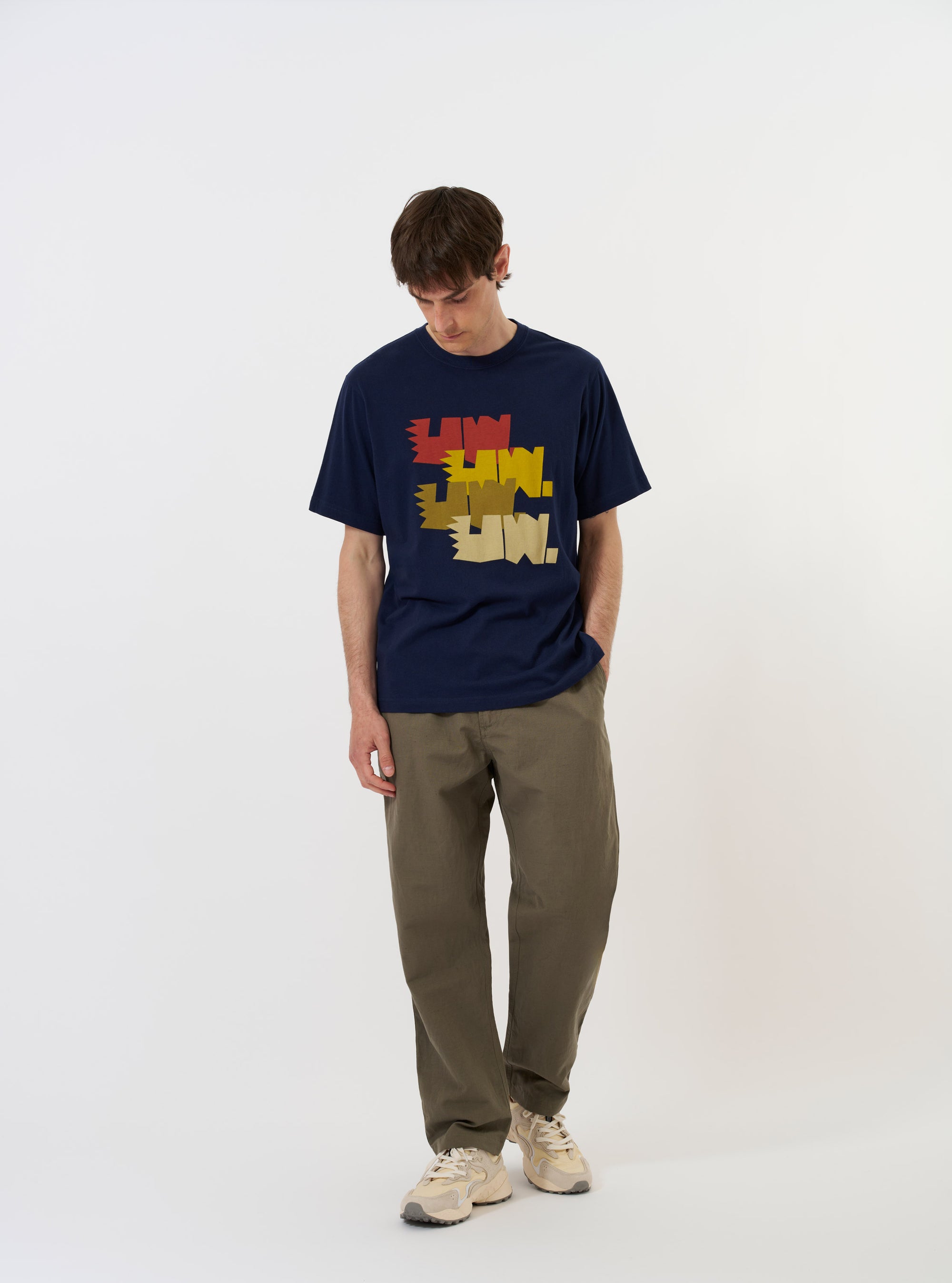 The Navy Single Jersey Multi UW Print Multi UW Print Tee is displayed flat against a plain white background. The navy blue t-shirt features a crew neck, short sleeves, and a prominent white graphic print repeating the initials UW across the front.