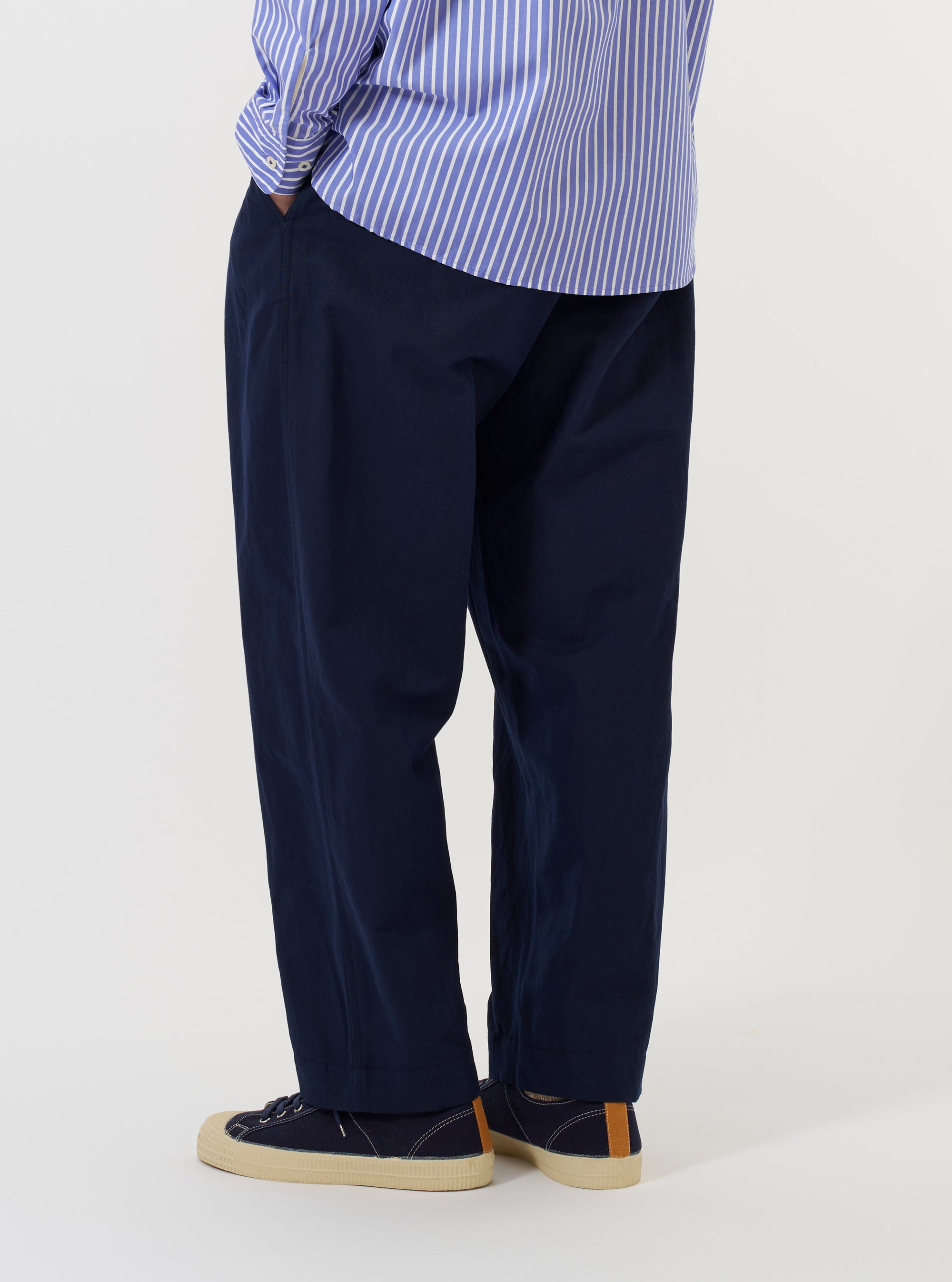 The back of the Navy Linen Slub Weave Oxford Pant is displayed flat against a plain white background. The image highlights the rear construction, featuring an elasticated waistband and two distinct back pockets: one with a buttoned flap and one button-jetted pocket.