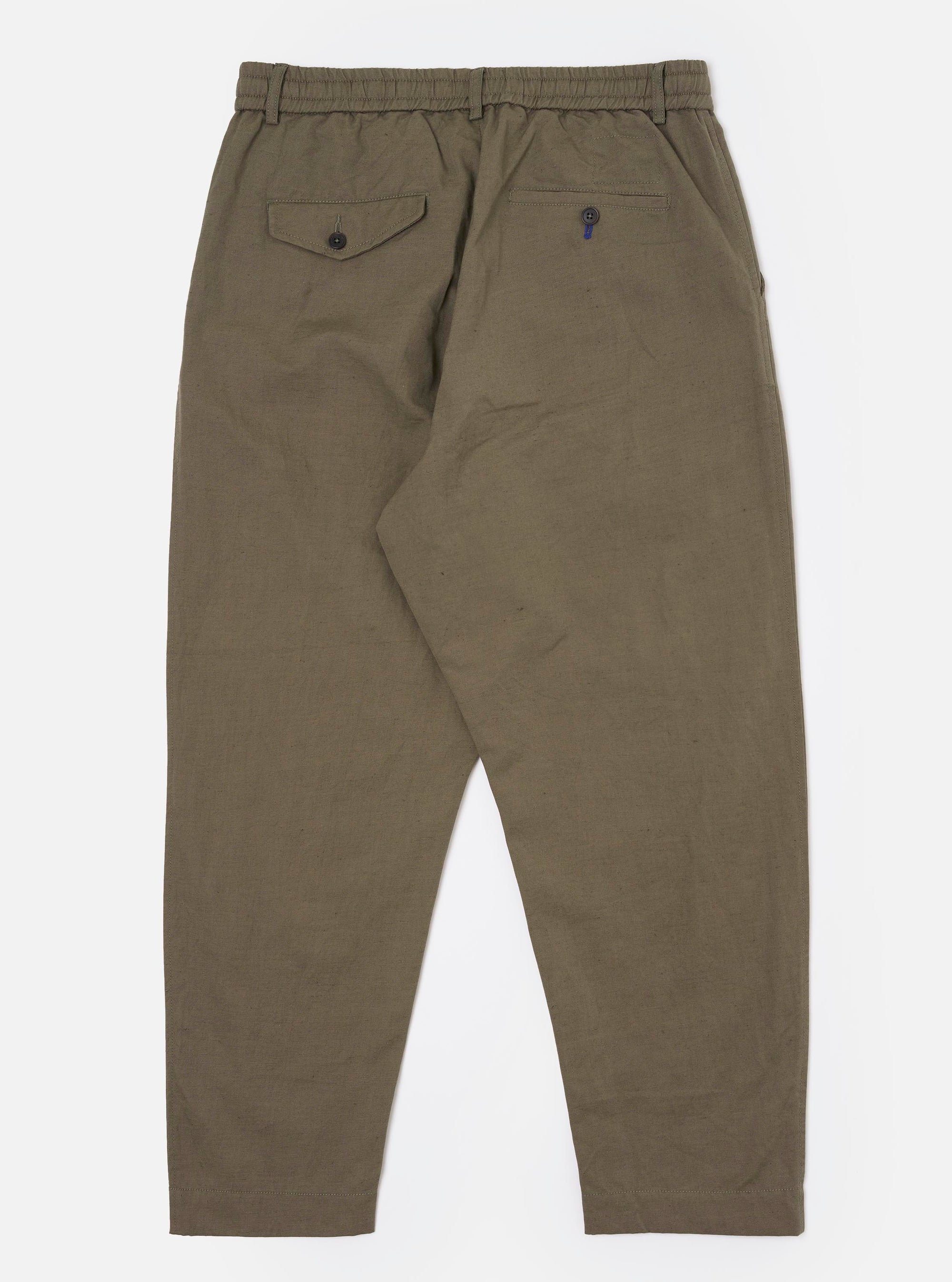 The Olive Linen Slub Weave Oxford Pant is shown from the back, laid flat against a plain white background. The image highlights the two rear patch pockets, one featuring a buttoned flap and the other a buttoned jetted design, alongside the elasticated waistband with visible tonal stitching. The olive green fabric displays a distinct textured slub weave.
