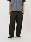 A model stands against a plain white background wearing the Olive Marl Tropical Suiting Dutch Pant. The image shows the trousers from the waist down, highlighting the loose, wide-leg fit and the textured olive green marl fabric. The model is also wearing dark shoes.