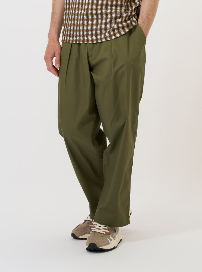 A pair of Olive Broadcloth Oxford Pants is shown laid flat against a solid white background. The trousers feature a wide, loose fit with a pleated front and a drawstring waistband.