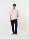 The Pale Pink Broadcloth Camp Shirt is shown laid flat against a solid white background. The shirt features a classic camp collar, a full button-down front, and a single patch pocket on the left chest. The short-sleeved garment is made from a smooth, light pink cotton broadcloth fabric.