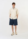 An Ecru Broadcloth Camp Shirt is displayed laid flat against a plain white background. The garment features a relaxed camp collar, short sleeves, and a full button-down front with a single chest pocket on the left side.