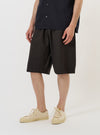A male model is wearing the Brown Marl Tropical Suiting Vacation Short against a plain white background. The shorts feature a relaxed fit and reach mid-thigh, paired with dark socks and black shoes. The model is shown from the waist down in a front-facing standing pose.