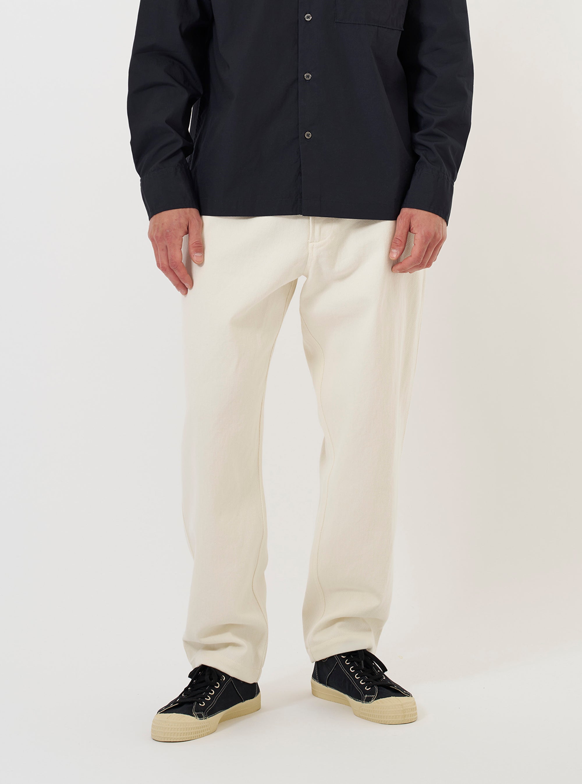 A model is wearing the Ecru Slub Drill Dizzy Trouser against a plain white background. The image shows the trousers from the waist down, highlighting the loose, wide-leg fit and the textured ecru cotton fabric. The model is standing straight and wearing dark shoes. No mannequin is present in the image.