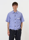 A model is wearing the Blue/White Cotton Stripe Z Tech Overshirt against a plain white background. The overshirt features a vertical blue and white stripe pattern, a single chest pocket with a visible zipper, and a classic pointed collar. The model is shown from the chest up, highlighting the technical details and fabric texture of the garment.