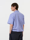 A model is wearing the Blue/White Cotton Stripe Z Tech Overshirt against a plain white background. The image provides a rear view of the model from the waist up, highlighting the horizontal back yoke and the vertical blue and white stripe pattern of the fabric. The model is standing straight with their arms at their sides.