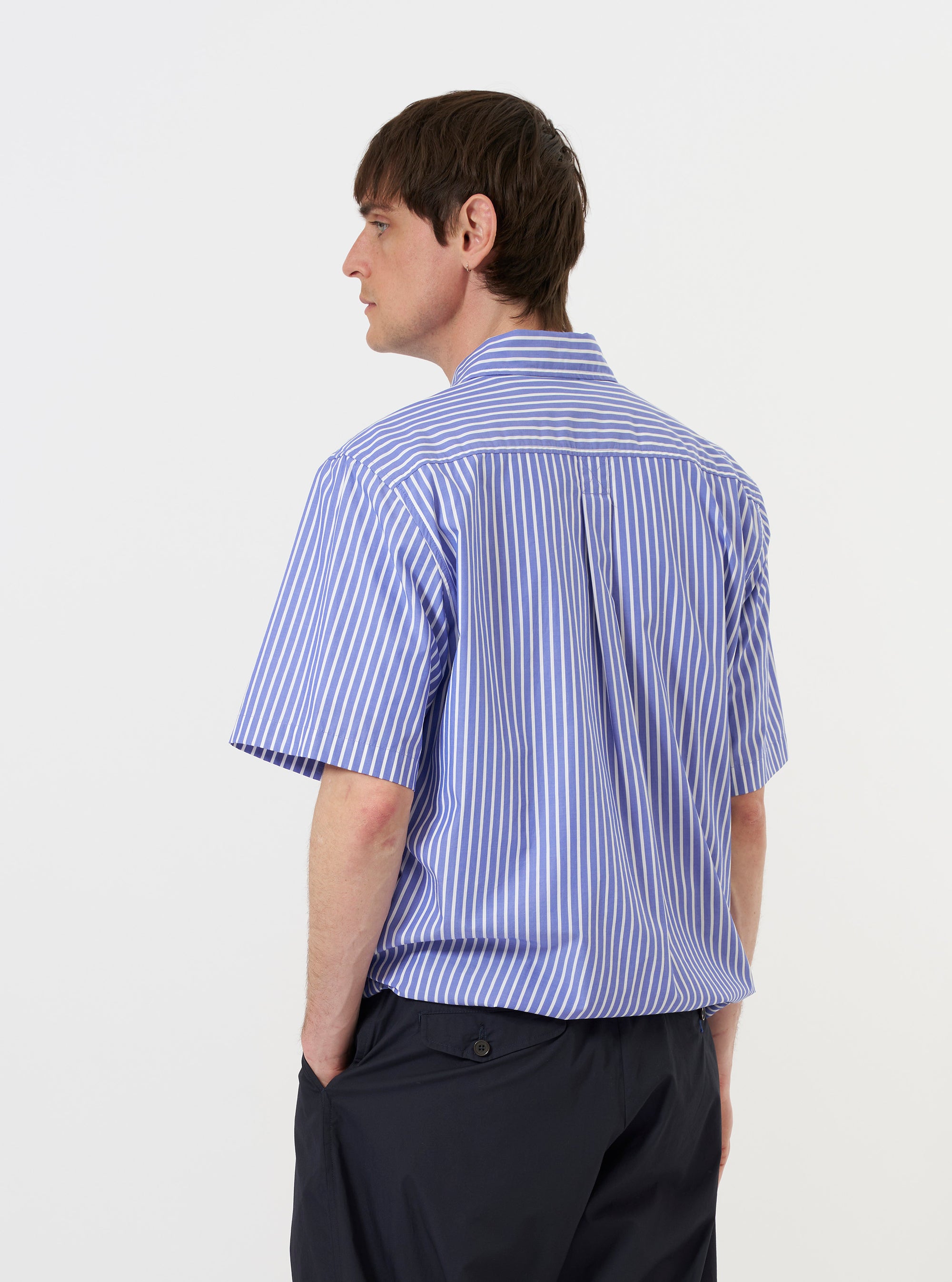 A model is wearing the Blue/White Cotton Stripe Z Tech Overshirt against a plain white background. The image provides a rear view of the model from the waist up, highlighting the horizontal back yoke and the vertical blue and white stripe pattern of the fabric. The model is standing straight with their arms at their sides.