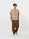 The Brown/White Cotton Stripe Z Tech Overshirt is shown laid flat against a plain white background. The garment features horizontal brown and white stripes, a classic pointed collar, a full button-down front, and two large chest pockets.