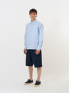 The Sky/White Classic Nipon Stripe Lazy Day Shirt is shown laid flat against a plain white background. The long-sleeve shirt features a vertical light blue and white stripe pattern, a classic pointed collar, and a full button-down front. A single asymmetric chest pocket is visible on the left side.
