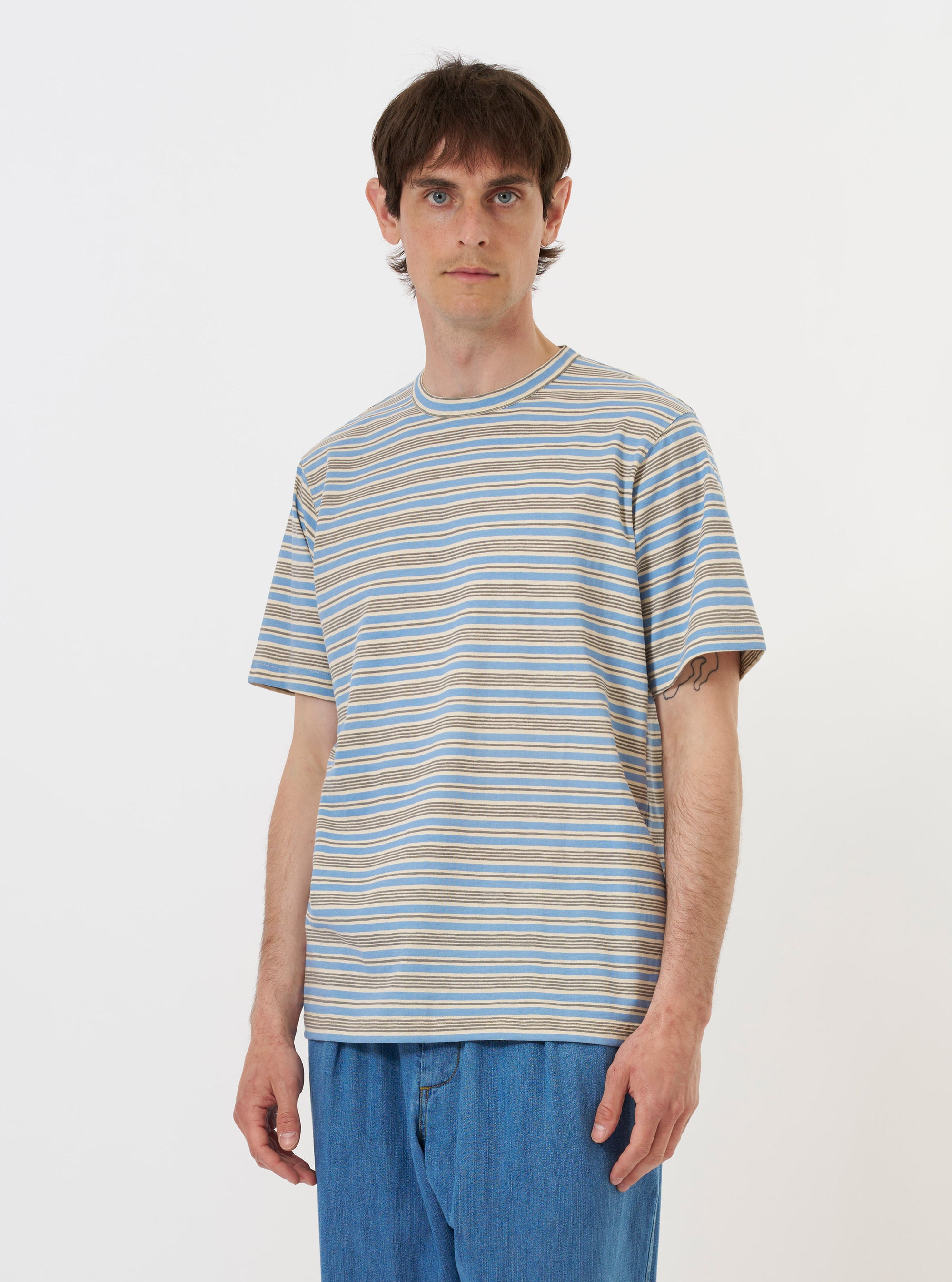 A Pale Blue OS Stripe Jersey Core Tee is shown laid flat against a solid white background. The short-sleeved t-shirt features a light blue and white horizontal stripe pattern and a self-bound crew neck.