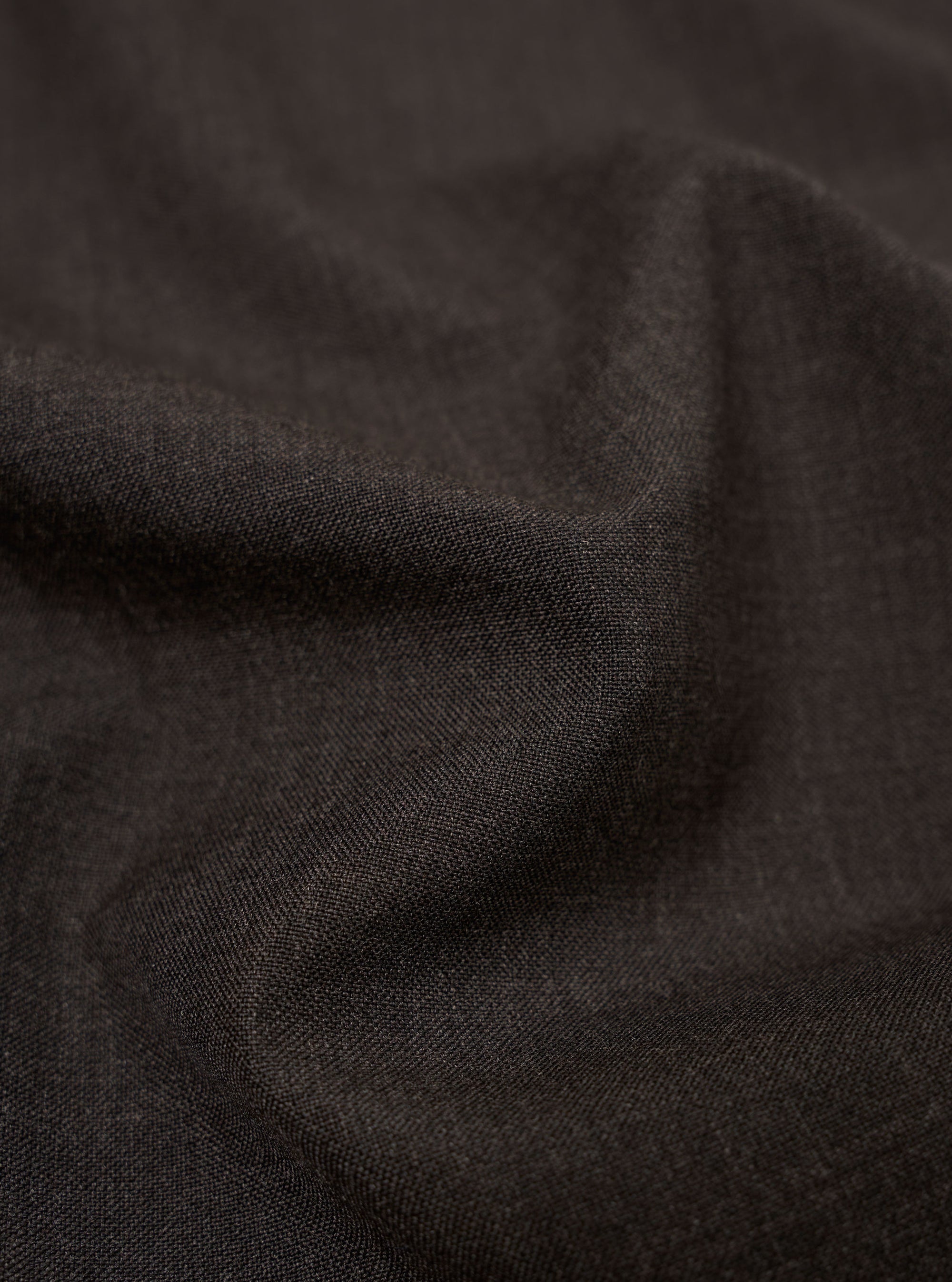 A close-up fabric swatch of the Brown Marl Tropical Suiting highlights the detailed texture and color of the material used for the Two Button Jacket. The image shows a fine, multi-tonal weave in shades of brown.