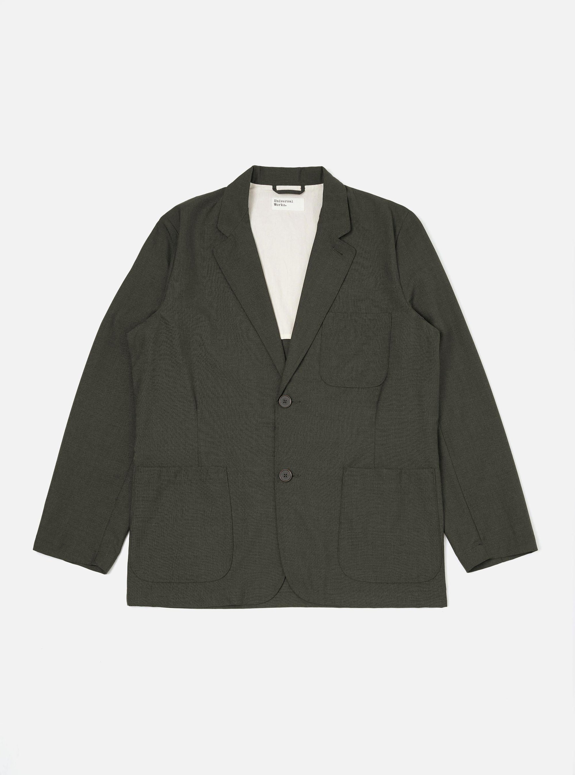 The Olive Marl Tropical Suiting Two Button Jacket is displayed flat against a plain white background. The jacket features a two-button front closure, a wide notched lapel, two large lower patch pockets, and a single chest patch pocket. The fabric has a textured olive green marl appearance.
