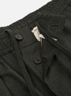 A pair of Olive Marl Tropical Suiting Pleated Track Pants is shown from the back, laid flat against a plain white background. The trousers feature a loose, tapered leg and an elasticated waistband. Key details include two distinct rear pockets, one with a buttoned flap and one jetted with a button closure.