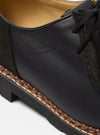 Close-up of the Paraboot x Universal Works Michael shoe in black leather and suede. Features include a welted sole and subtle branding. Shot on a clean white background.