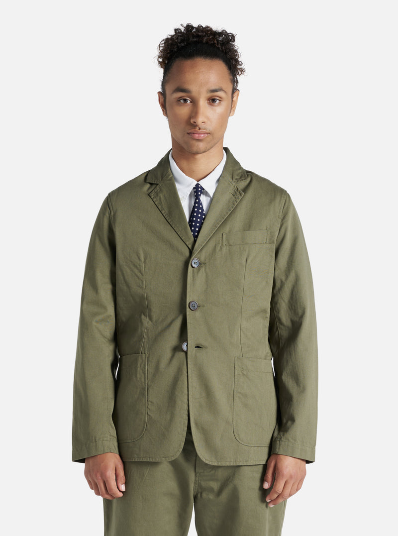 A model wears a Light Olive Twill London Jacket. The twill jacket is styled with a white shirt and navy tie, against a plain white backdrop.