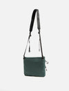 The F/CE.® Green Nylon 2.5 Layer Sacoche, a compact bag with a black strap, is displayed against a white background. The bag is made of green nylon material.