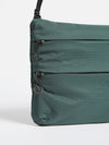 Close-up of the F/CE.® Green Nylon 2.5 Layer Sacoche on a white background. The bag features a textured green nylon material, black zippers, and a black adjustable strap.