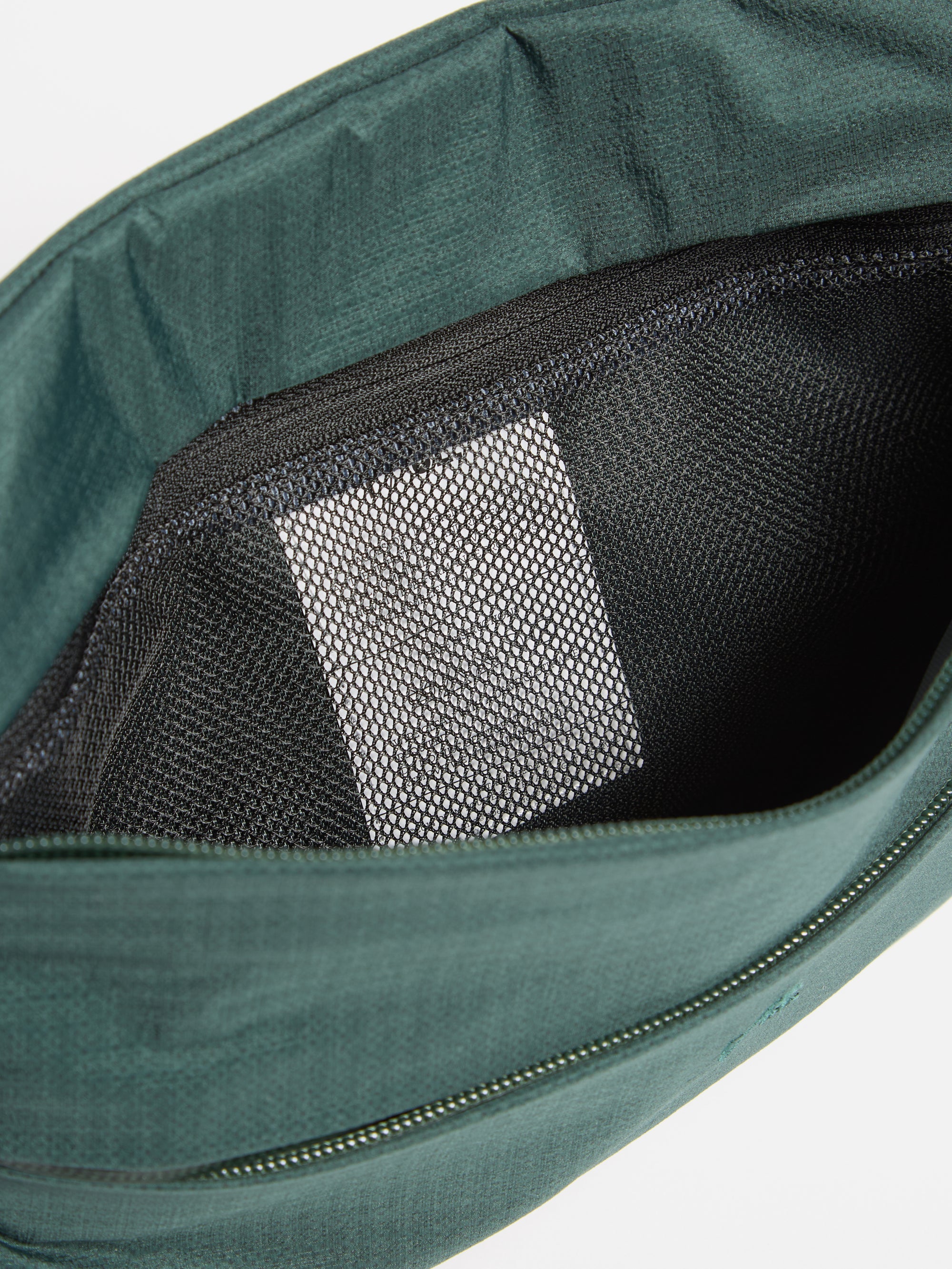 Close-up of the F/CE.® Green Nylon 2.5 Layer Sacoche interior, showing a black mesh pocket against a plain white background. The sacoche is a deep green color.