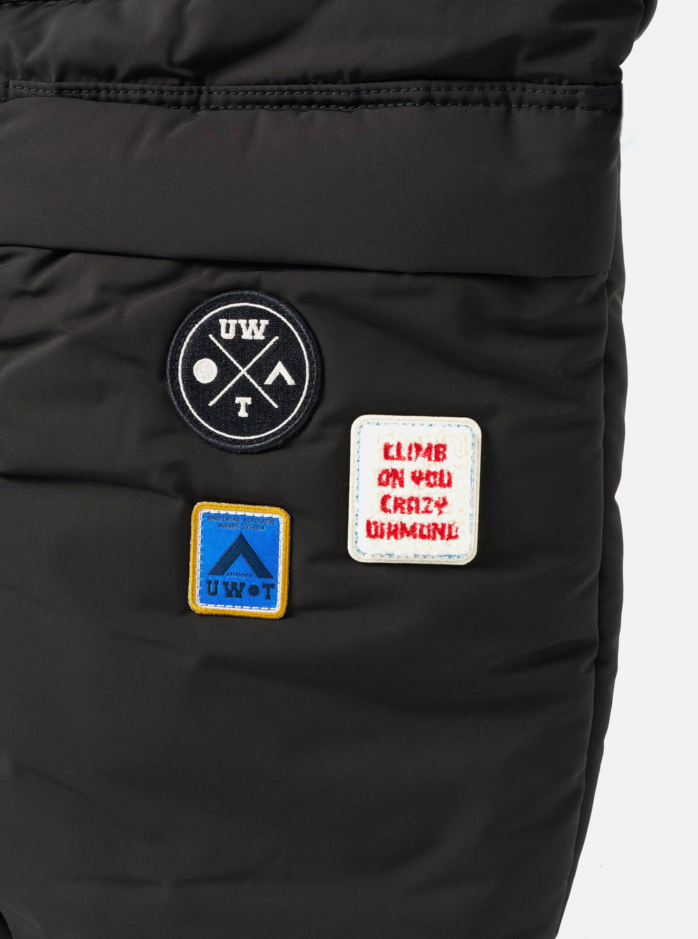 Close-up of the Topologie x Universal Works Black UW Tech Helmet Bag. Features black material and patches. Patches include UW logo, UWOT, and "Climb on you crazy diamond".