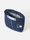 Topologie x Universal Works Insignia Blue UW Tech Helmet Bag on a white background. The bag is navy with light blue straps and patches.