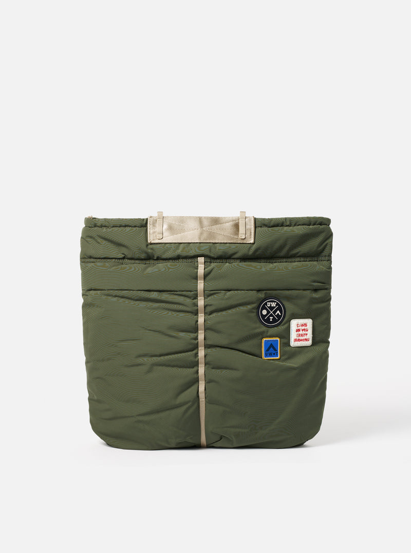 Topologie x Universal Works Rifle Green UW Tech Helmet Bag on a white background. The bag is quilted with beige straps and patches.